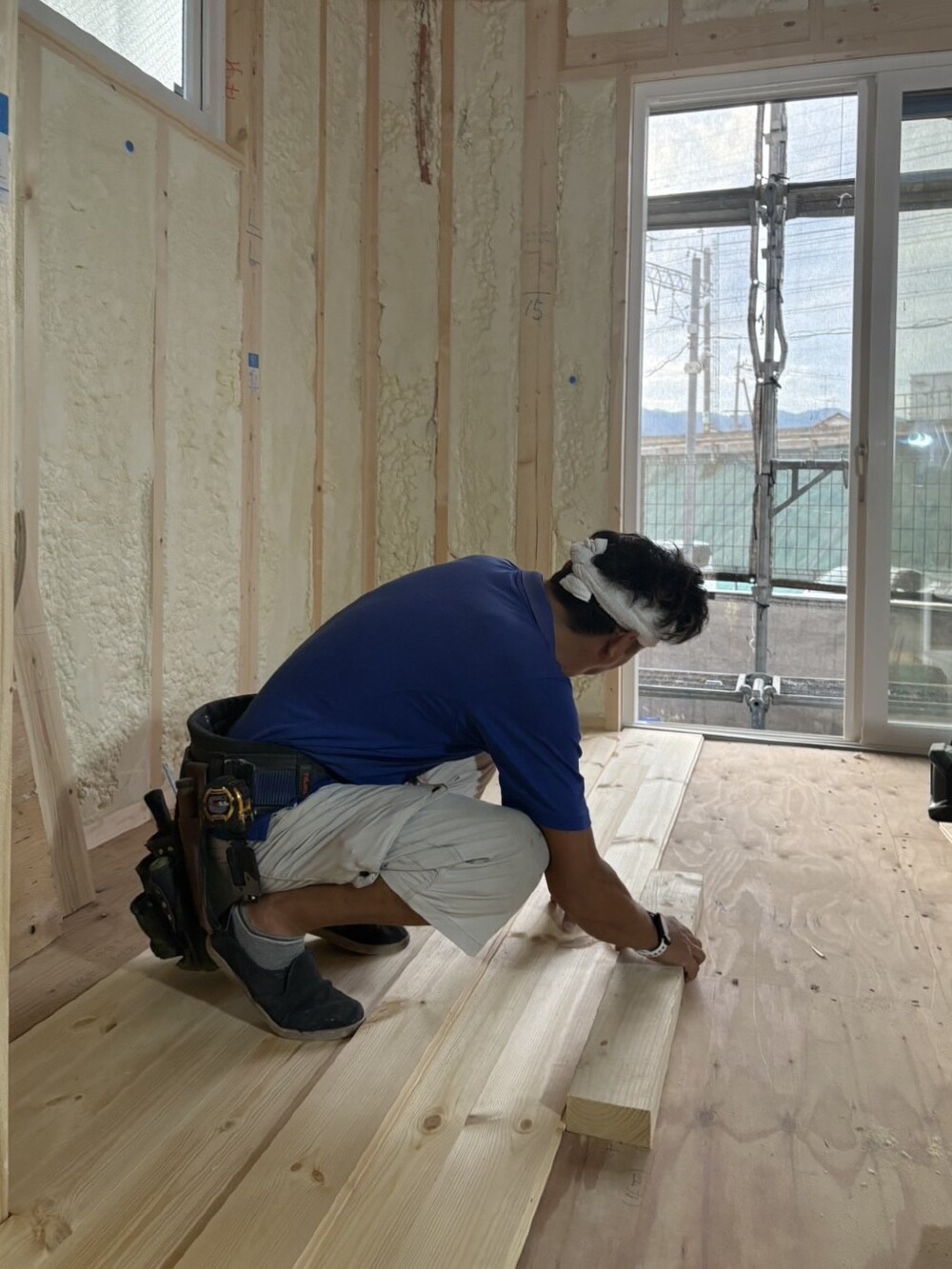 株式会社ハウスサポート｜アイリーフラボの建築中現場で、大工さんがフローリング張りの作業風景です。